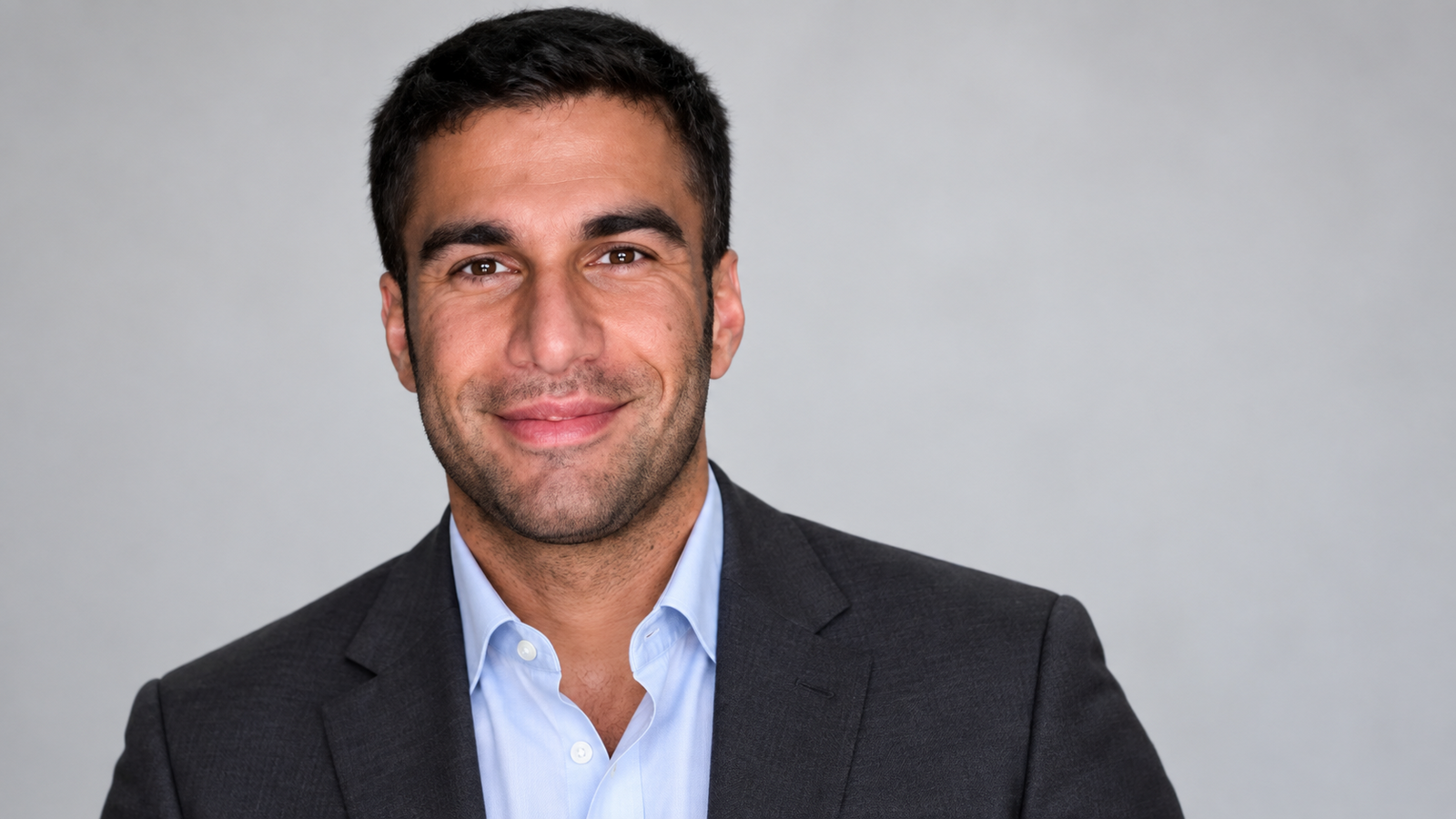 AI-generated editorial portrait of Ramtin Abdo in a dark blazer and pale-blue shirt against a light background.