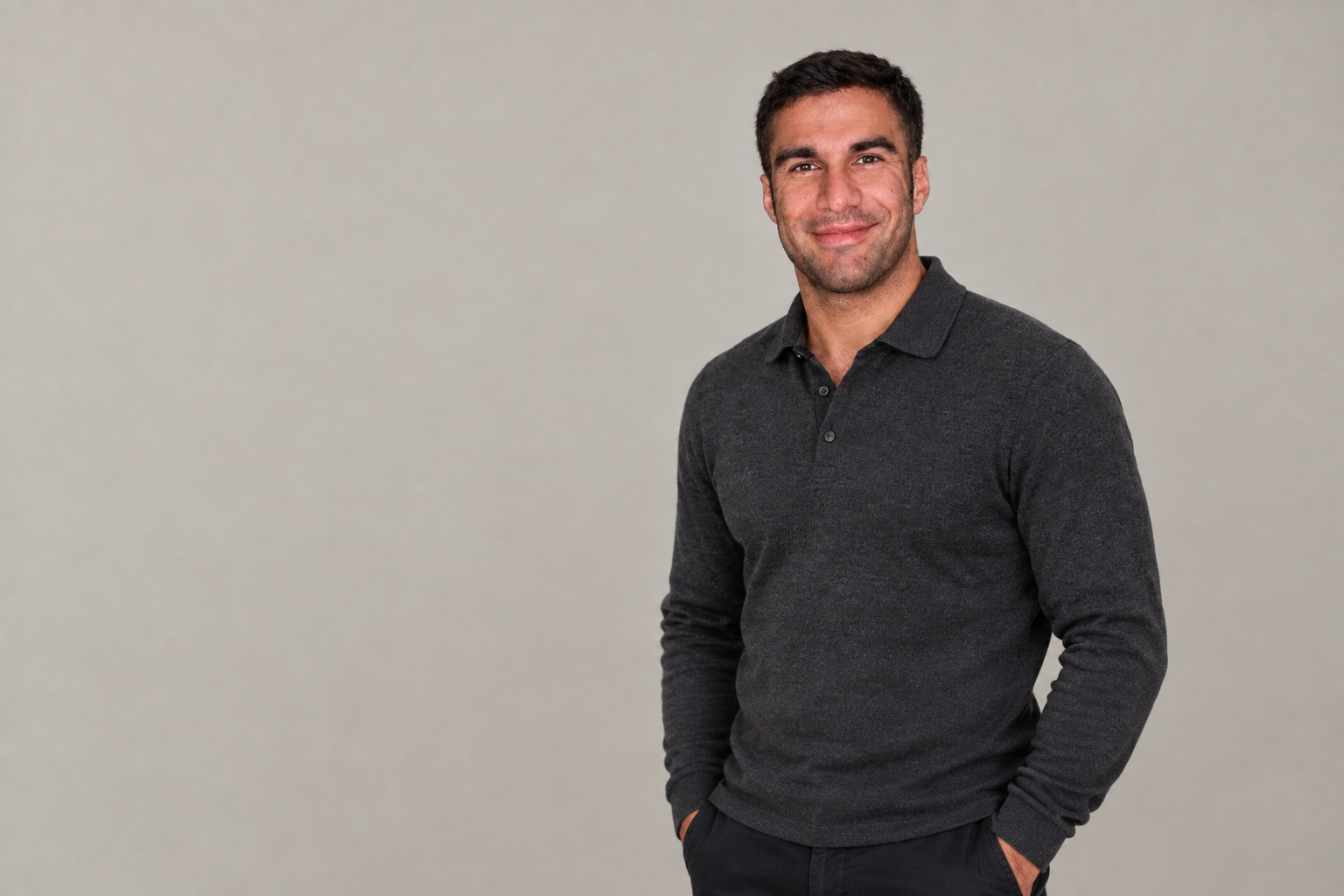 Editorial portrait illustration of Ramtin Abdo in a charcoal collared top against a warm-grey background.